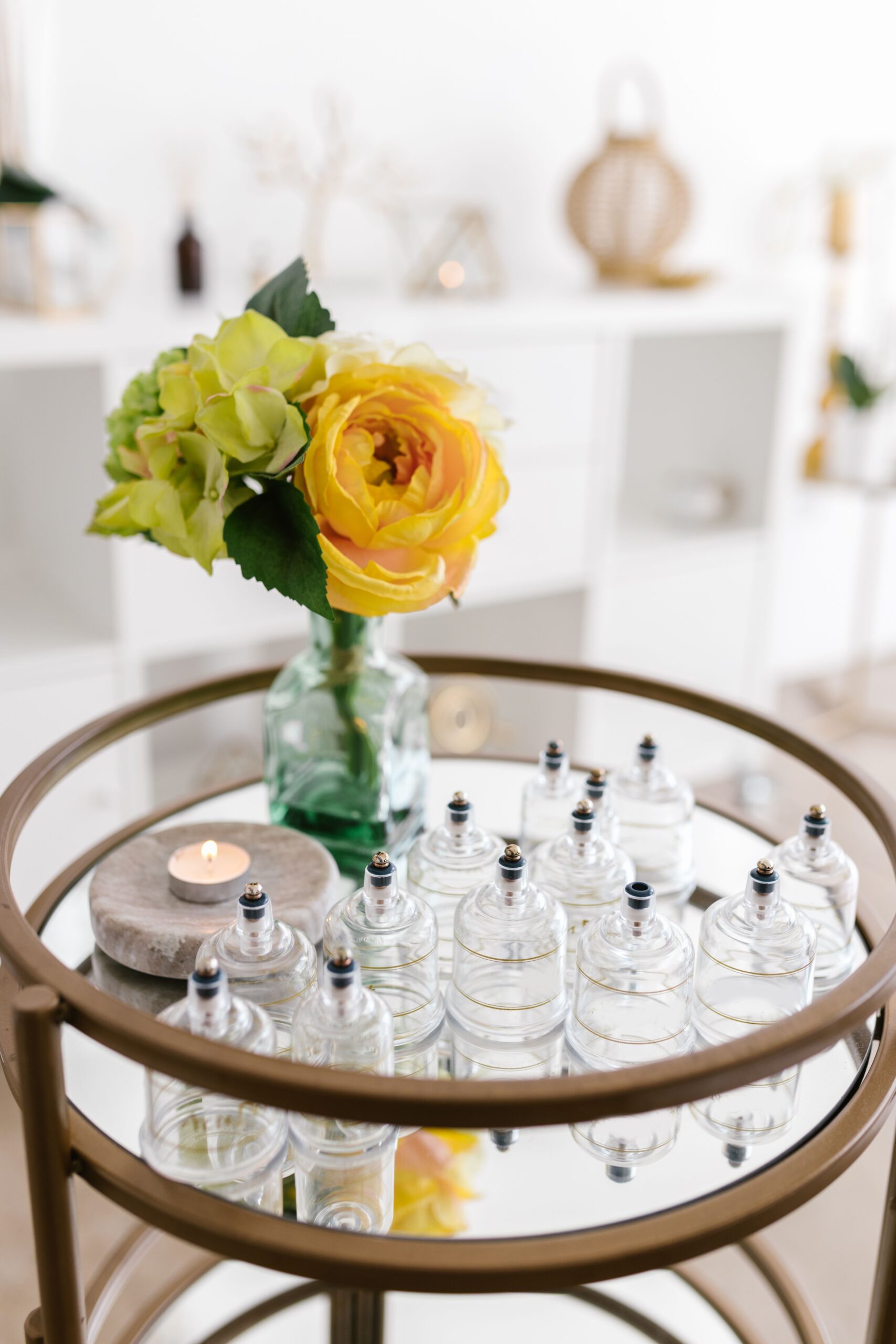 Sophisticated tabletop arrangement featuring a yellow rose in a vase and cupping glasses, perfect for wellness themes.